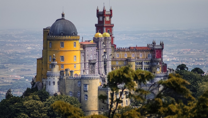 Viajar para Portugal é muito mais do que um destino turístico; é uma viagem ao coração da cultura, história e beleza natural. Ao pisar em solo português, você se vê imerso em uma terra onde o passado e o presente se entrelaçam de forma harmoniosa. Das ruas de pedra de Lisboa, onde o fado ecoa em cada esquina, às praias deslumbrantes da Nazaré, onde as ondas gigantes desafiam surfistas do mundo todo, Portugal oferece uma experiência única para cada tipo de viajante.

Cada cidade portuguesa conta uma história. Em Porto, o aroma do vinho homônimo que envelhece nas caves ao longo do Rio Douro convida você a uma degustação que transcende o paladar, revelando séculos de tradição. Em Sintra, os palácios de contos de fadas e os jardins exuberantes parecem saídos de um sonho, evocando uma época de realeza e mistério. Já no Alentejo, a tranquilidade das planícies douradas convida à introspecção, oferecendo uma pausa revigorante da agitação do dia a dia.

Portugal é também um paraíso para os amantes da gastronomia. Saborear um pastel de nata fresquinho em uma pastelaria de Lisboa, degustar frutos do mar preparados com perfeição em uma taverna à beira-mar no Algarve, ou brindar com um vinho verde em uma adega familiar são experiências que vão muito além de uma simples refeição. É uma conexão com as raízes de um povo que valoriza o sabor e a qualidade em cada prato.

Mas o verdadeiro encanto de Portugal está nas pessoas. A hospitalidade calorosa dos portugueses faz com que você se sinta em casa, seja em uma pequena vila rural ou em um animado bairro urbano. Eles compartilham com orgulho suas tradições, histórias e segredos locais, garantindo que sua viagem seja enriquecida com momentos autênticos e inesquecíveis.

Viajar para Portugal não é apenas visitar monumentos ou paisagens deslumbrantes; é uma jornada que toca a alma, onde cada experiência é uma oportunidade de se conectar com algo mais profundo. É um país que encanta, inspira e deixa uma marca duradoura em todos que o exploram. Ao partir, você não estará simplesmente indo embora; estará levando consigo um pedaço de Portugal no coração.